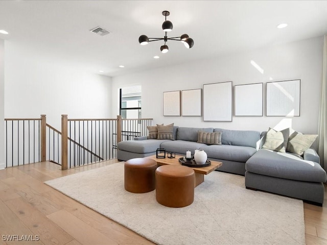 living room with a notable chandelier and light wood-type flooring