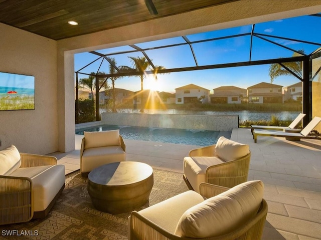 view of patio featuring a lanai, outdoor lounge area, and a water view