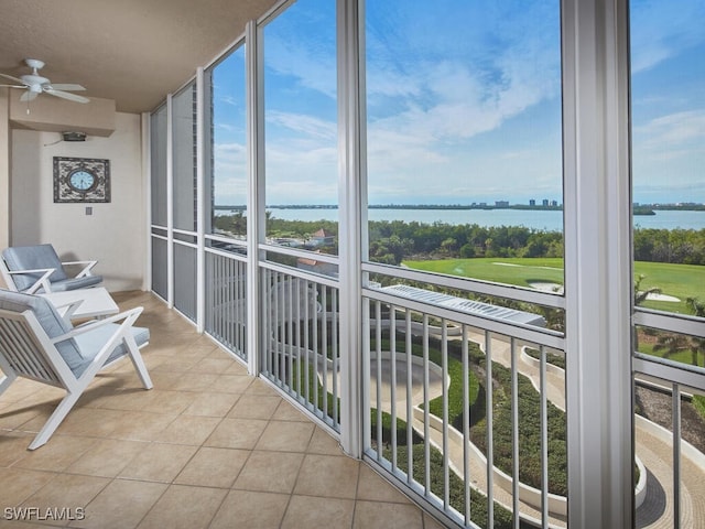 sunroom with a water view and ceiling fan