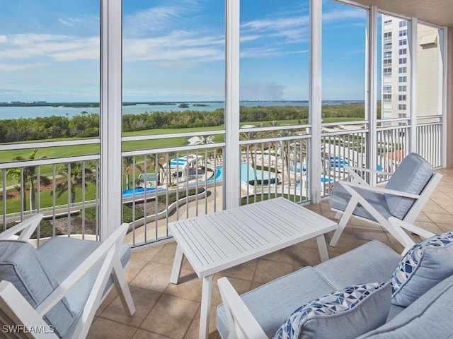 sunroom featuring a water view