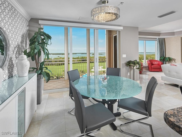 dining room featuring a water view and a chandelier