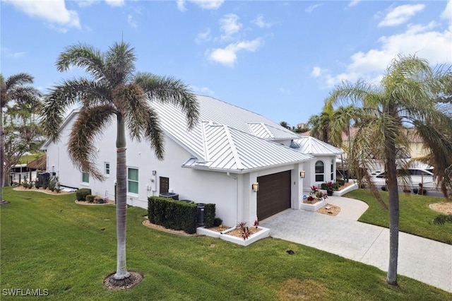 view of property exterior featuring decorative driveway, a yard, stucco siding, an attached garage, and a standing seam roof