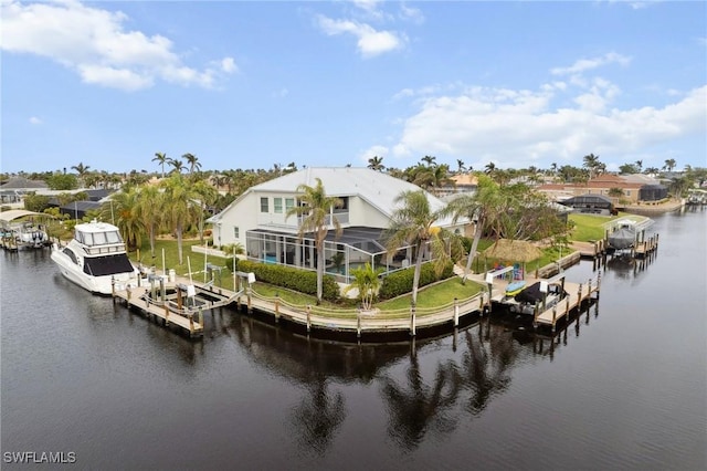 back of property featuring boat lift, a water view, a lanai, and a residential view