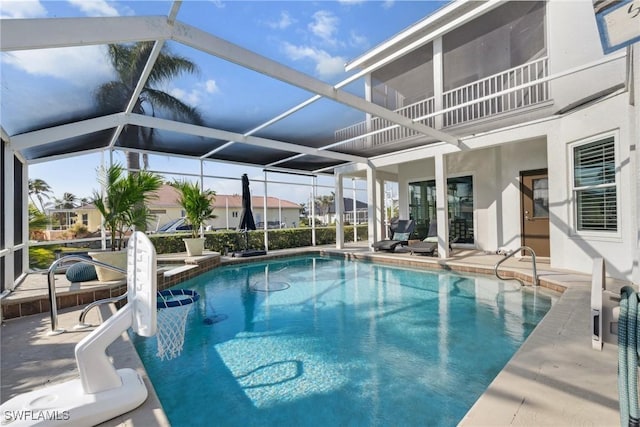 view of pool featuring glass enclosure and a patio area