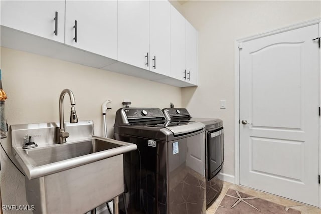 laundry area with cabinet space, washing machine and dryer, light tile patterned floors, and a sink