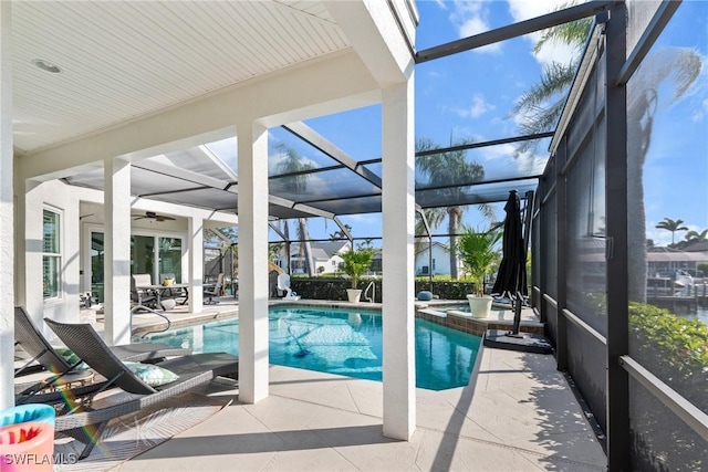 view of pool featuring a patio, a pool with connected hot tub, and glass enclosure