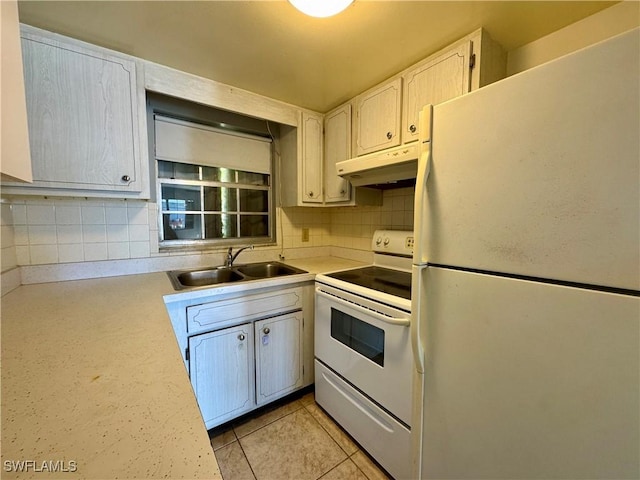 kitchen featuring tasteful backsplash, white appliances, a sink, and under cabinet range hood