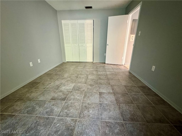 unfurnished bedroom with visible vents, baseboards, and a closet