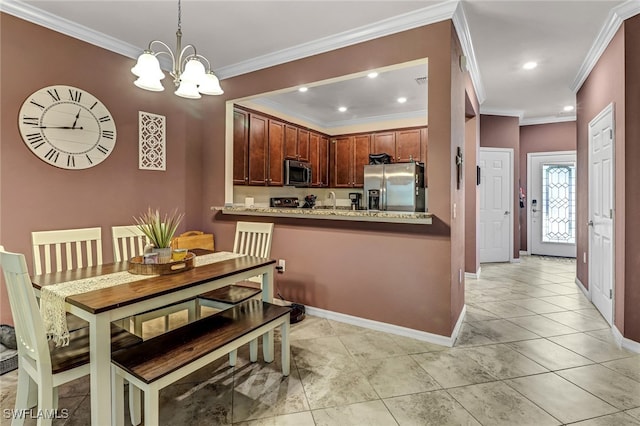 kitchen with kitchen peninsula, ornamental molding, appliances with stainless steel finishes, and a chandelier