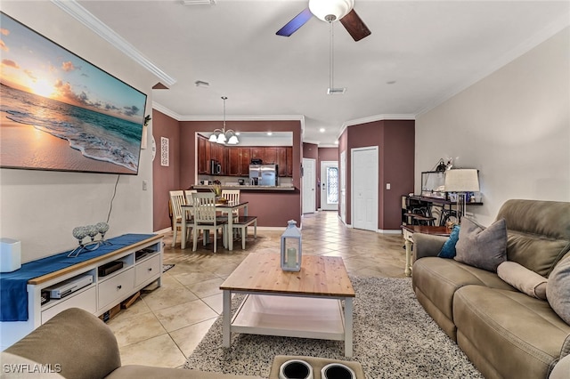 tiled living room with ceiling fan with notable chandelier and crown molding