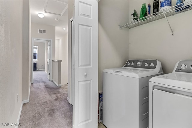 laundry area with separate washer and dryer and light carpet