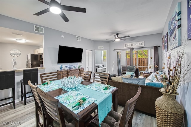 dining area with ceiling fan and light hardwood / wood-style floors