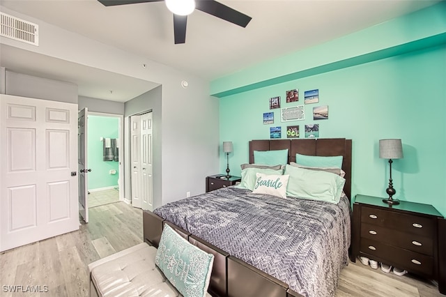 bedroom featuring ceiling fan, light hardwood / wood-style floors, connected bathroom, and a closet