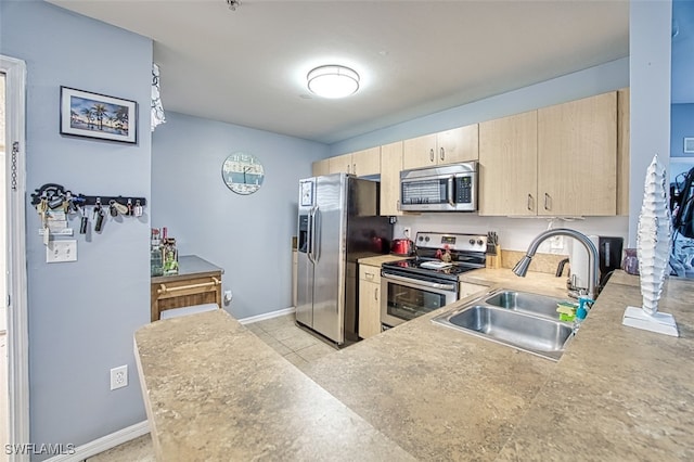 kitchen with kitchen peninsula, appliances with stainless steel finishes, light brown cabinets, and sink