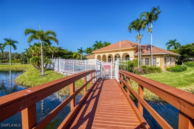 dock area featuring a fenced in pool, a yard, and a water view