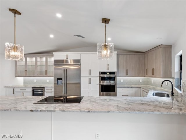 kitchen featuring appliances with stainless steel finishes, light brown cabinetry, sink, wine cooler, and hanging light fixtures