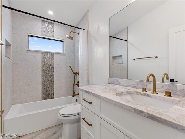 full bathroom with tiled shower / bath combo, vanity, and toilet