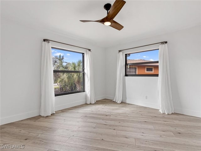 empty room with ceiling fan and light hardwood / wood-style flooring