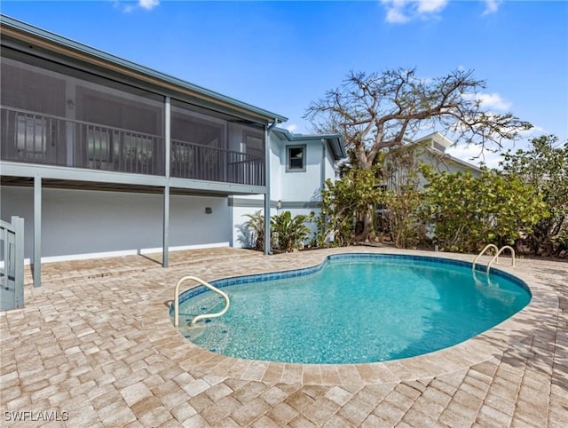 view of pool with a patio and a sunroom