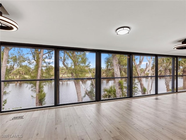 unfurnished sunroom featuring a healthy amount of sunlight and a water view