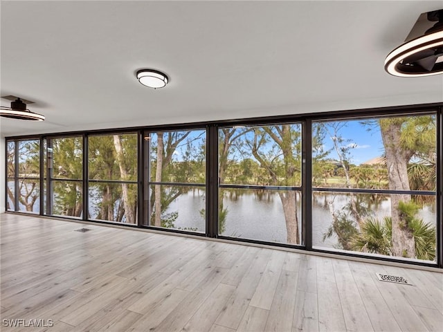 interior space with plenty of natural light, ceiling fan, and a water view