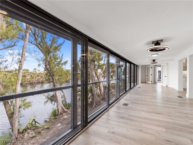 unfurnished sunroom featuring a water view