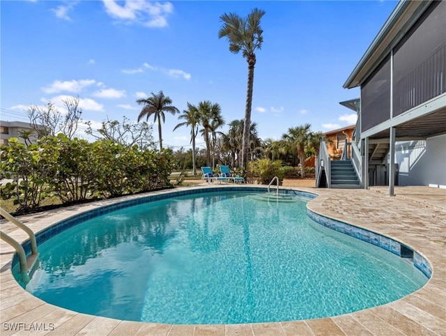 view of pool featuring a patio area and a sunroom