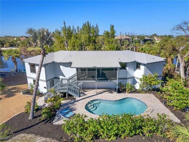 view of swimming pool with a patio, a water view, and a sunroom