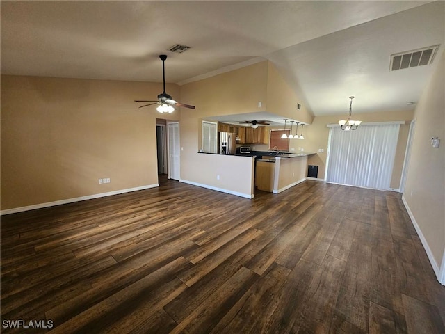 unfurnished living room featuring ceiling fan with notable chandelier, dark hardwood / wood-style flooring, sink, and vaulted ceiling