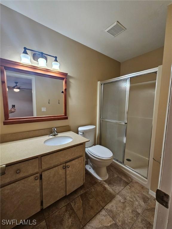 bathroom featuring vanity, toilet, and walk in shower