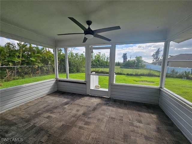 unfurnished sunroom featuring a wealth of natural light and ceiling fan