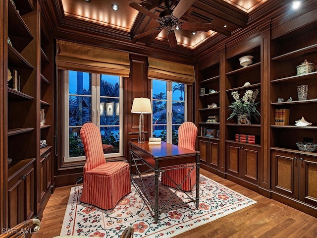 home office featuring coffered ceiling, wooden walls, built in shelves, beam ceiling, and ceiling fan