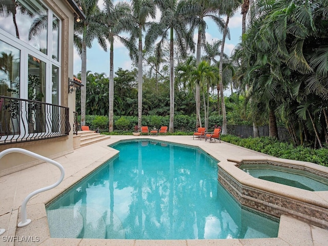 view of swimming pool with an in ground hot tub and a patio