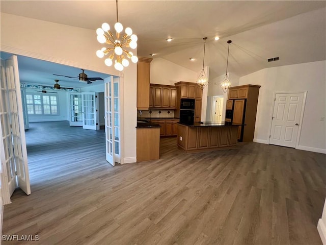 kitchen featuring ceiling fan with notable chandelier, hanging light fixtures, and dark wood-type flooring