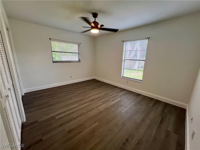 unfurnished bedroom with ceiling fan and dark wood-type flooring