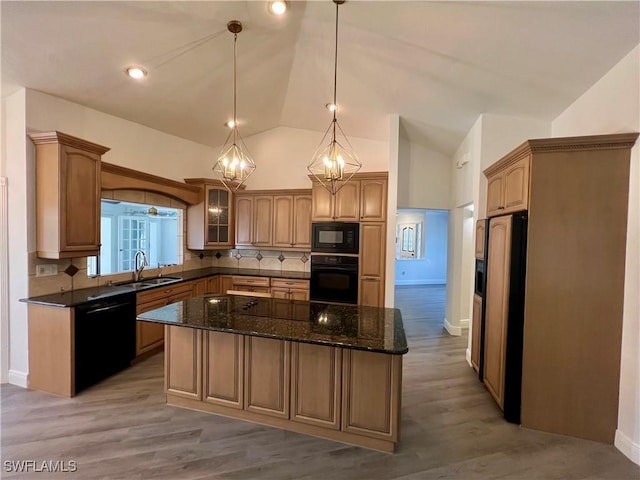 kitchen featuring a center island, backsplash, black appliances, sink, and hanging light fixtures