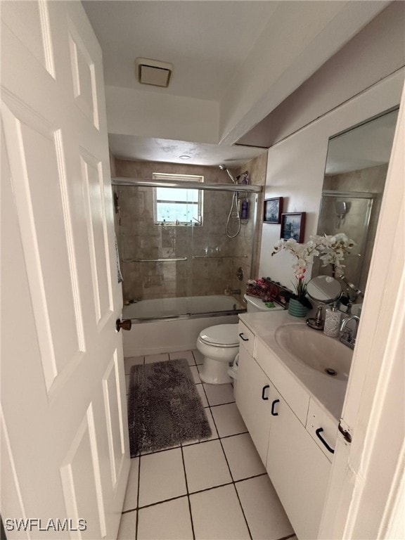 full bathroom with tile patterned flooring, vanity, bath / shower combo with glass door, and toilet