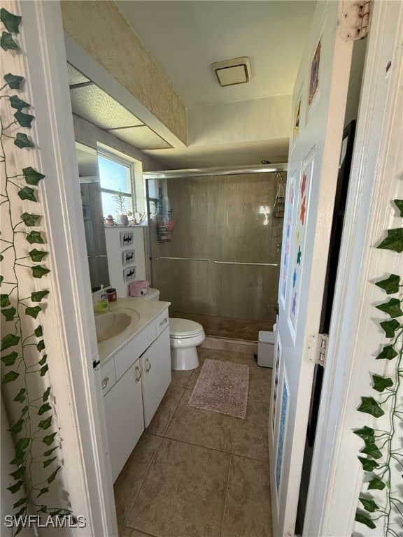 bathroom with tile patterned floors, vanity, toilet, and an enclosed shower