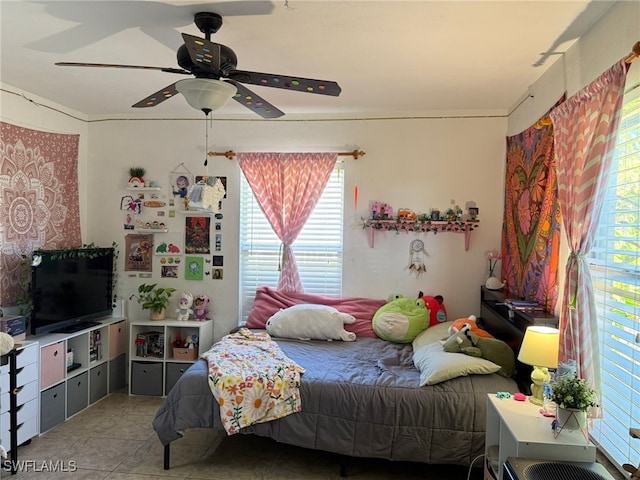 tiled bedroom with ceiling fan and ornamental molding