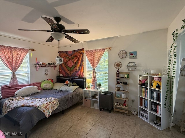 bedroom featuring tile patterned floors, ceiling fan, and multiple windows