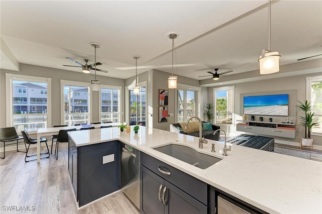 kitchen with ceiling fan, stainless steel dishwasher, hanging light fixtures, and sink