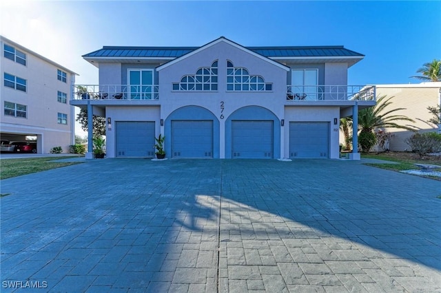 view of front of property featuring a balcony and a garage