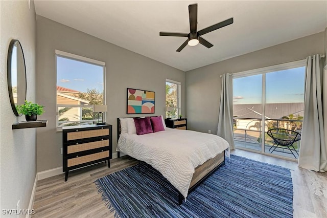 bedroom with hardwood / wood-style floors, ceiling fan, and access to outside