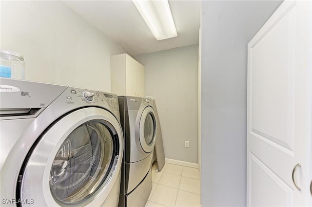 clothes washing area featuring washer and clothes dryer and light tile patterned flooring