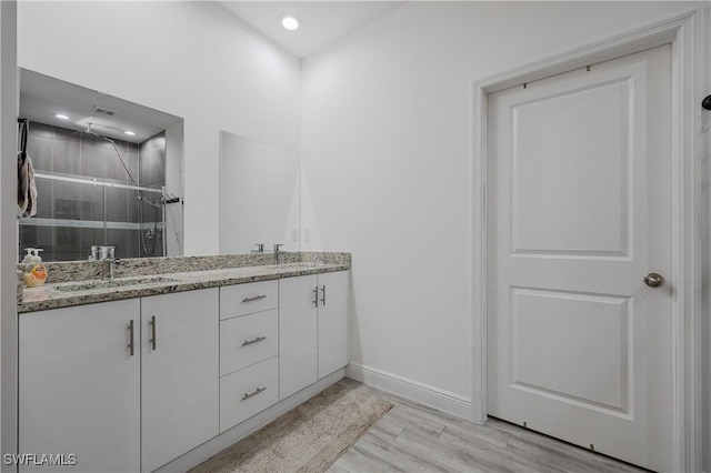 bathroom with vanity, wood-type flooring, and a shower with door