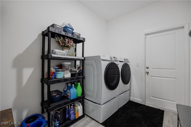 washroom featuring separate washer and dryer and light hardwood / wood-style flooring