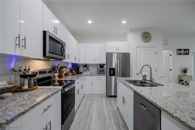 kitchen with backsplash, white cabinetry, light stone counters, and appliances with stainless steel finishes