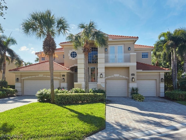 mediterranean / spanish home with a garage, a balcony, and a front yard