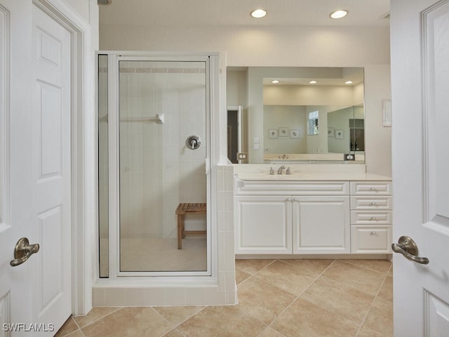 bathroom featuring tile patterned flooring, vanity, and a shower with shower door