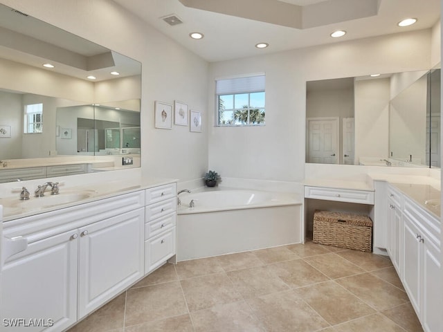 bathroom with tile patterned flooring, a washtub, and vanity